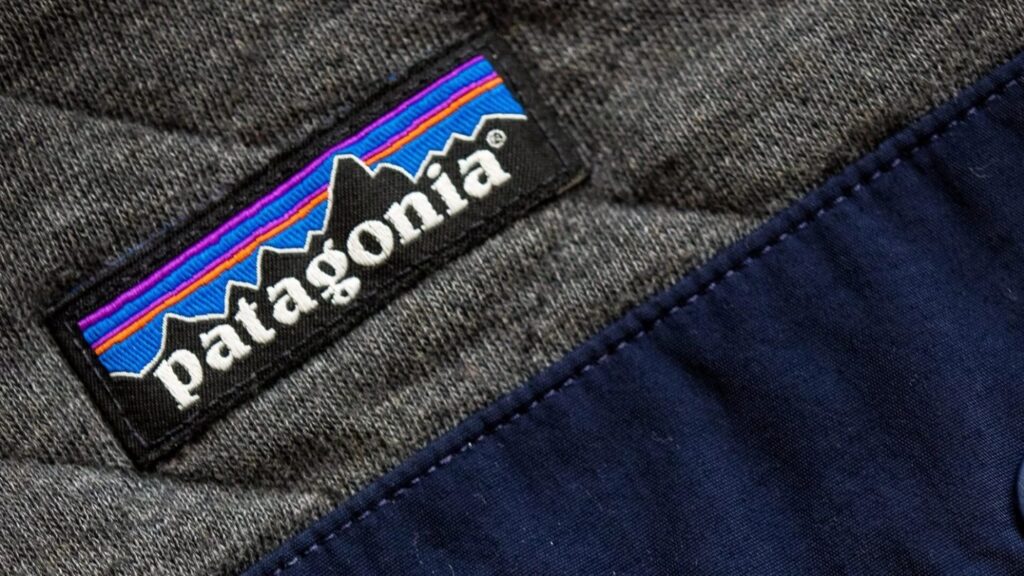 Close-up of a Patagonia logo patch stitched onto a grey and navy fabric garment.