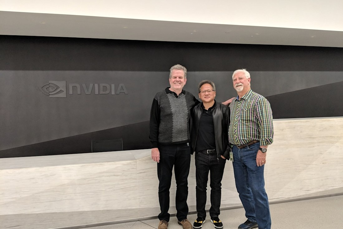 NVIDIA co-founders Jensen Huang, Chris Malachowsky, and Curtis Priem standing together in front of the NVIDIA logo at company headquarters.