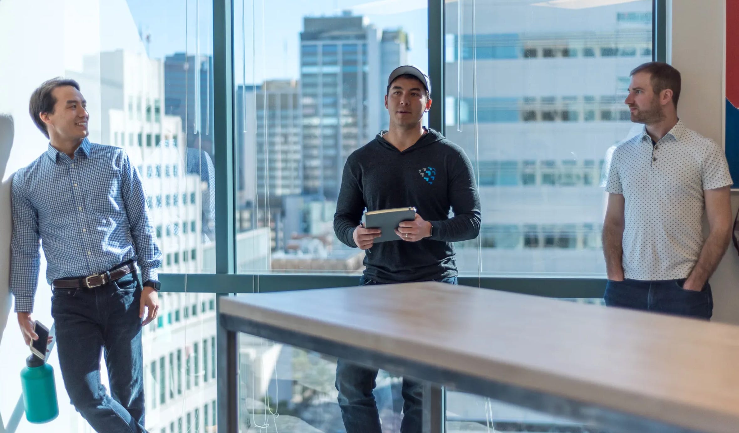 Shield AI founders Ryan Tseng, Brandon Tseng, and Nathan Michael standing together, representing the leadership behind the autonomous defense tech company.